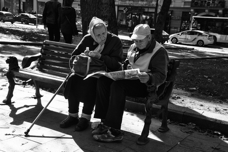 LVIV / UKRAINE - OCTOBER 06, 2018: Two old women rest on a bench, Svobody av. in Lviv cityのeditorial素材