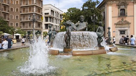 VALENCIA / SPAIN - AUGUST 07, 2019: Plaza de la Virgen,  Turia Fountain. Neptune seated above the virgins that represent, allegorically, the canals fed by the river Turiaのeditorial素材