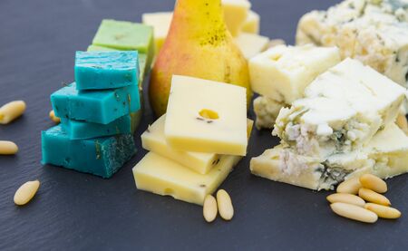 Various types of cheese, pear and pine nutsの写真素材