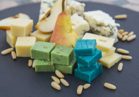 Various types of cheese, pear and pine nuts