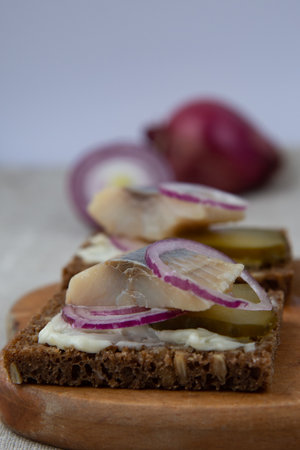 Sandwiches of rye bread with herring, onions and cucumber
