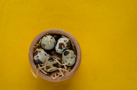 Happy Easter. Quail eggs in the wooden basket, selective focus