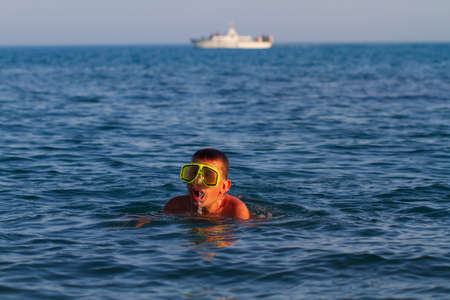 Boy swims and dives in a swimming maskの写真素材