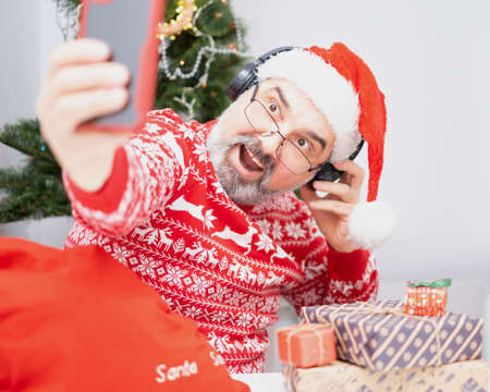 Portrait of nice, attractive, cheerful, positive bearded Santa making selfie. Christmas greetings conceptの写真素材
