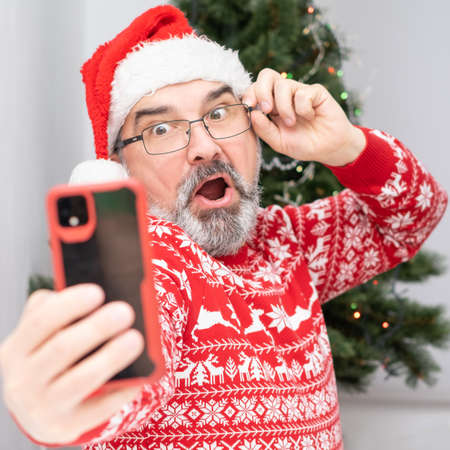 Portrait of nice, attractive, cheerful, positive bearded Santa making selfieの写真素材