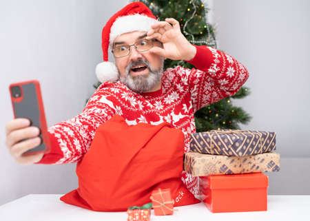 Portrait of nice, attractive, cheerful, positive bearded Santa making selfie. Christmas greetings...
