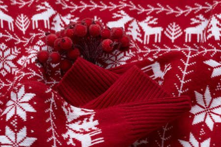 A bouquet of winter berries on a red sweater. Christmas or New Year conceptの写真素材