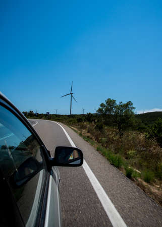 Wind turbines generating electricity over blue sky background. Green renewable alternative energy...