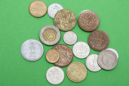 Coins of different countries. A scattering of coins on a green background. Shallow depth of field,...