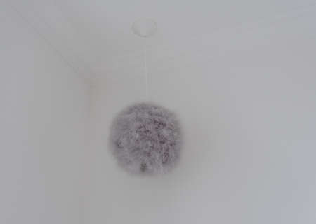 White ceiling with a large gray ball of wool hanging from the ceilingの写真素材