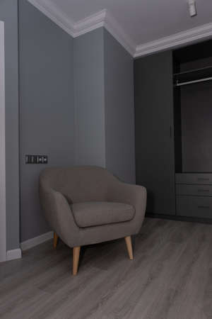 Modern living room interior with grey armchair and wardrobe. Real photoの写真素材