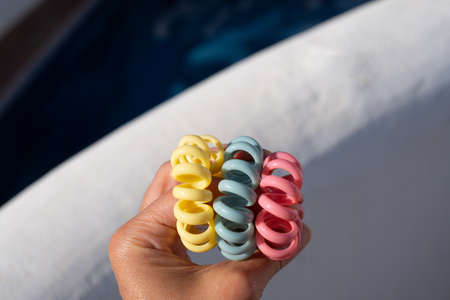 Plastic spiral scrunchies hair band in the hand. Colored spiral hair bandsの写真素材