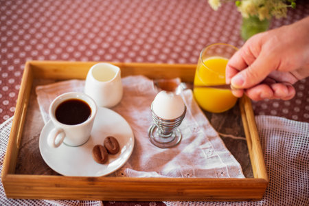 Breakfast with boiled egg, orange juice and coffee. Sunny morningの写真素材