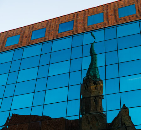 Reflection of the old temple in the facade of a new modern mirror building. Old and modern architecture of Wroclawの写真素材