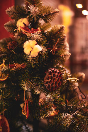 Fir branch with eco friendly organic decor and festive lights on the Christmas background with sparkles. New Year's composition Merry Christmas! Happy New Year! copy spaceの写真素材