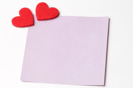 Close-up of a short pink note paper with a red heart. Valentines day background. Copy for writing...