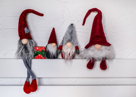 Christmas Elves decorations. Four dwarves with Christmas holiday present is sitting on a wooden...