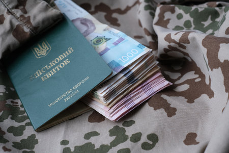 Ukrainian military ID and hryvnia on military uniform. Payments to soldiers of the Ukrainian army, salaries to the military. War in Ukraineの写真素材