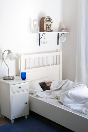 Childroom, Lifestyle,relaxing home concept. Boy lies in a bed on a white bedclothes