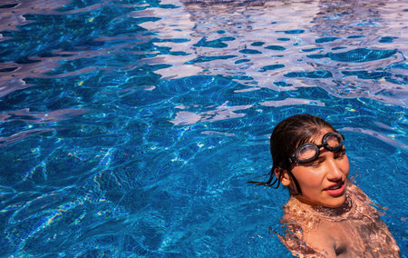 Boy in a swimming pool. Sport activities for children, outdoor swimming lessons. Summer vacation at the hotel. Outdoor swimming pool. healthy lifestyle conceptの写真素材