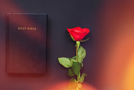 Holy Bible and red roses on the black and red background. Christian concept, copy spaceの写真素材