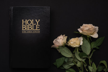 White roses and Holy Bible on the black background. Christian concept , copy spaceの写真素材