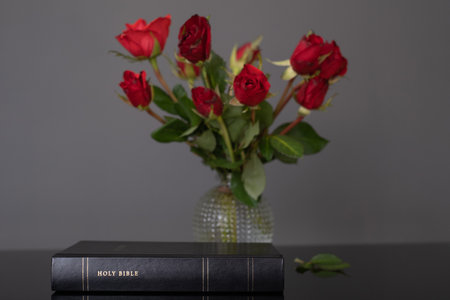 Holy Bible and red roses on the table. Christian concept, copy spaceの写真素材