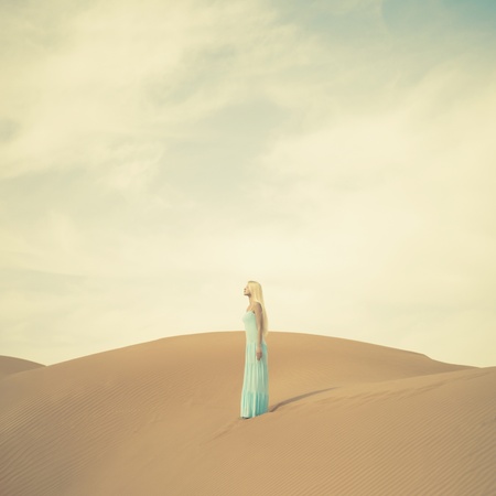 Beautiful blonde in a blue dress in an orange desert. UAEの写真素材