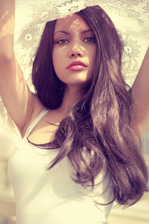 Beautiful brunette and the sun's rays through the laceの写真素材
