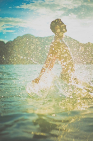 Young man enjoying the sea at sunsetの写真素材