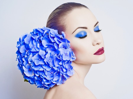 Fashion portrait of beautiful young lady with blue hydrangeaの写真素材