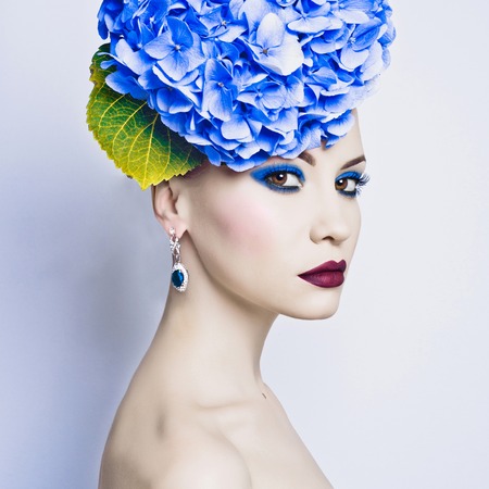 Fashion portrait of beautiful young lady with blue hydrangeaの写真素材