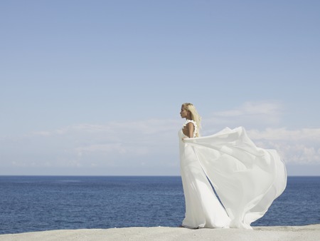 Fashion photo of beautiful elegant bride at the seashoreの写真素材