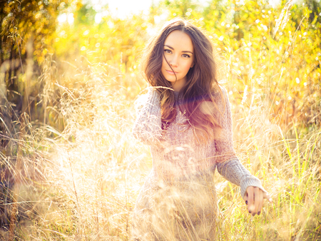 Outdoor fashion photo of young beautiful lady in autumn landscapeの写真素材