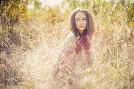 Outdoor fashion photo of young beautiful lady in autumn landscapeの写真素材