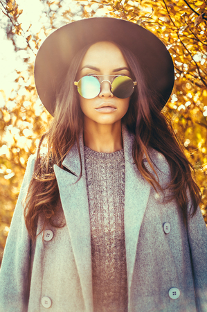 Outdoor fashion photo of young beautiful lady surrounded autumn leavesの写真素材