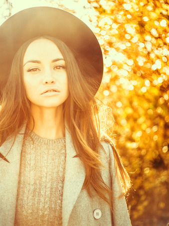 Outdoor atmospheric fashion photo of young beautiful lady in autumn landscapeの写真素材