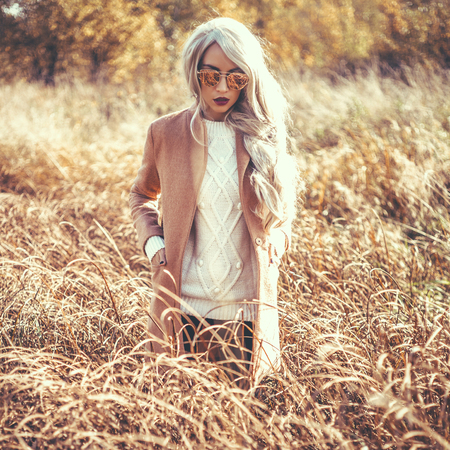 Outdoor atmospheric fashion photo of young beautiful lady in autumn landscapeの写真素材