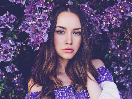 Outdoor fashion photo of beautiful young woman surrounded by flowersの写真素材