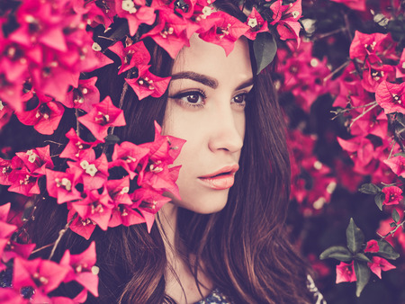 Outdoor fashion photo of beautiful young woman surrounded by flowersの写真素材