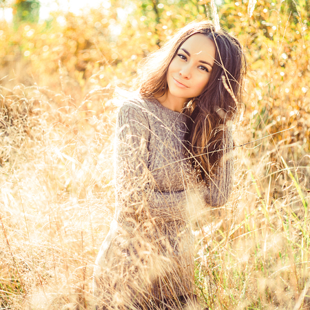 Outdoor atmospheric fashion photo of young beautiful lady. Autumn field. Autumn lanscape. Warm autumn. Warm springの写真素材