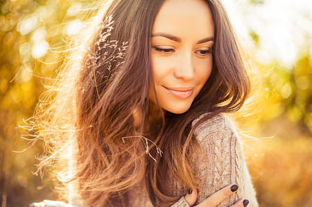 Outdoor atmospheric lifestyle photo of young beautiful lady. Brown hair and eyes. Warm autumn. Warm spring