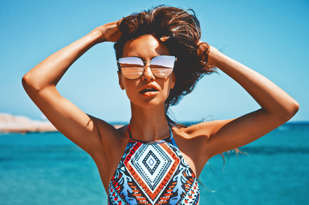 Outdoor fashion photo of beautiful happy woman at sea. Beach travel. Summer vibesの写真素材