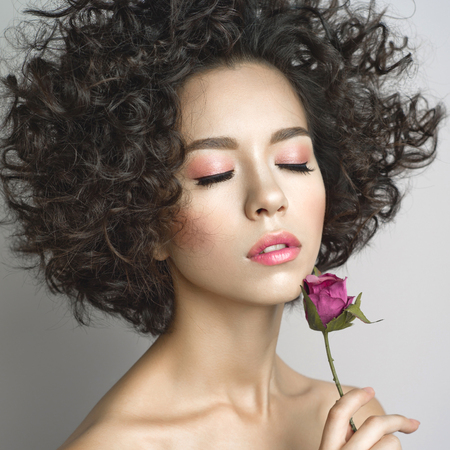 Studio fashion photo of beautiful young woman with violet rose.  Valentines day. Spring blossomの写真素材