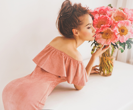 Lifestyle photo of beautiful young woman with pink peonies. Bouquet as gift. Emotions of happiness and joy. Valentines day. Mothers dayの写真素材