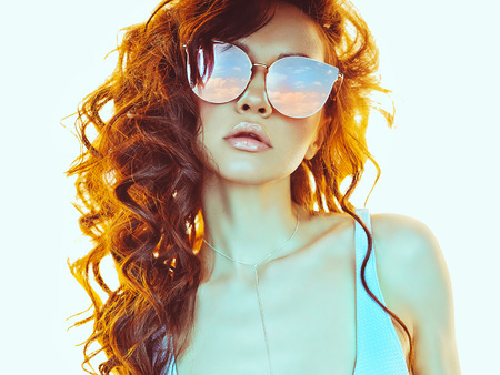 Sunny fashion photo of beautiful woman in pink-blue sunglasses. Beach summer vibesの写真素材
