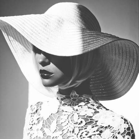 Black and white outdoor fashion photo of young beautiful lady in hat and sunglasses. Summer Beach travel. Summer vibesの写真素材