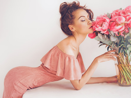 Lifestyle photo of beautiful young woman with pink peonies. Bouquet as gift. Emotions of happiness and joy. Valentines day. Mothers dayの写真素材