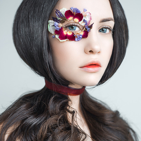 Art fashion portrait of beautiful woman with bright makeup decorated with flowers. Fantasy girl portrait. Summer fairy portrait. Long hairの写真素材