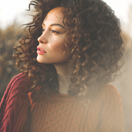 Outdoor atmospheric lifestyle photo of young beautiful lady. Brown hair and eyes. Warm fall. Autumn vibes. Softness, warmth and comfortの写真素材
